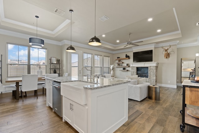 kitchen featuring a wealth of natural light, a tray ceiling, decorative light fixtures, and white cabinets