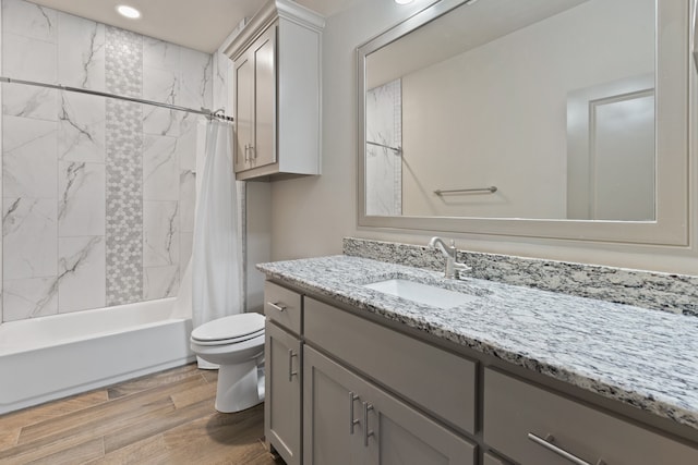 full bathroom featuring toilet, vanity, shower / bath combo with shower curtain, and hardwood / wood-style floors