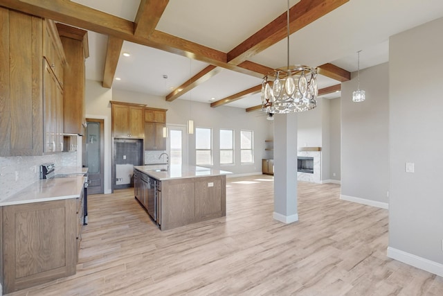 kitchen with decorative backsplash, a kitchen island with sink, a chandelier, light hardwood / wood-style floors, and stainless steel electric range oven