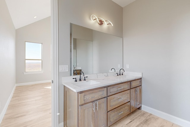 bathroom featuring hardwood / wood-style floors, vanity, and lofted ceiling