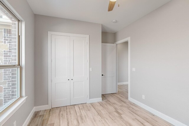 unfurnished bedroom featuring ceiling fan, a closet, and light hardwood / wood-style floors