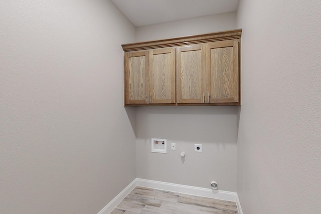 washroom with cabinets, washer hookup, electric dryer hookup, light hardwood / wood-style flooring, and hookup for a gas dryer