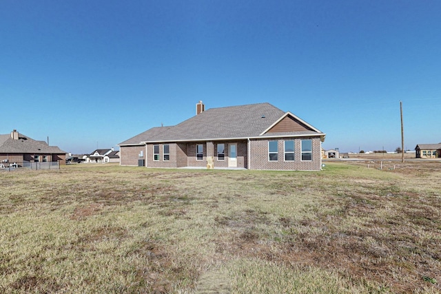 rear view of property with a lawn