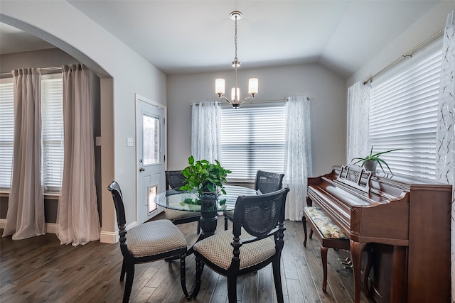 dining room with lofted ceiling, a chandelier, a healthy amount of sunlight, and dark hardwood / wood-style flooring