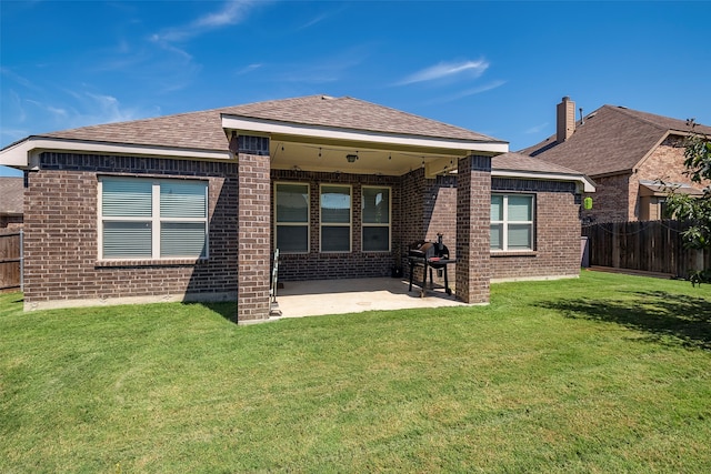 back of property with a lawn and a patio