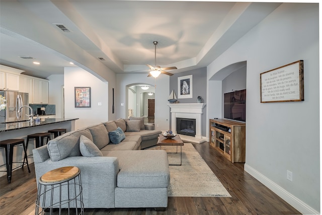 living room with ceiling fan and dark hardwood / wood-style flooring