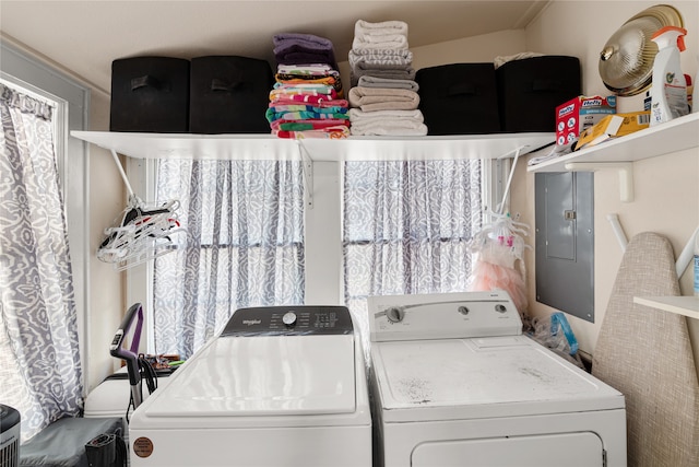 laundry room with electric panel and washer and clothes dryer