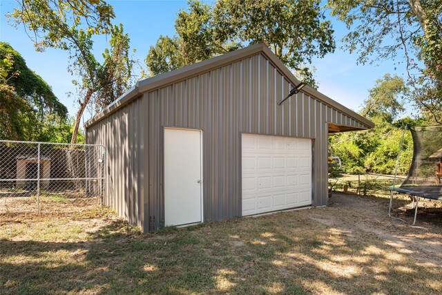 505 S Boyd, Lindale, TX 75771 - detached garage with fence, dirt driveway, and a trampoline