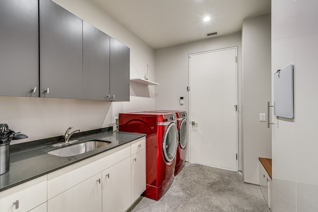 washroom featuring cabinets, washing machine and dryer, and sink