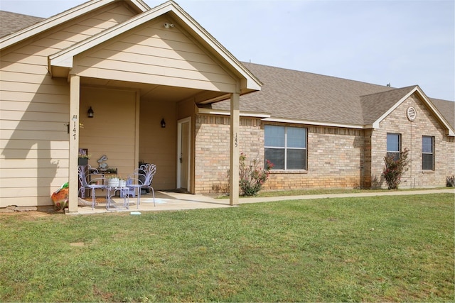 view of front of house with a front yard and a patio area