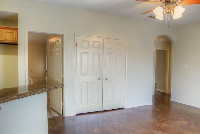 interior space featuring a closet, visible vents, baseboards, finished concrete floors, and arched walkways