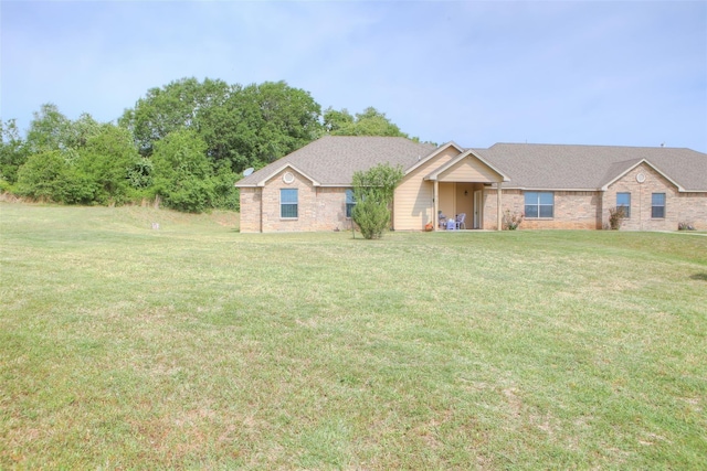 ranch-style house featuring a front yard and brick siding