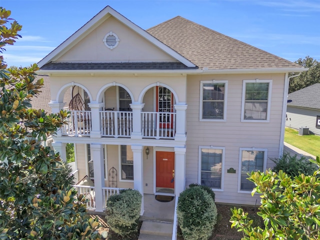 view of front facade with covered porch, a balcony, and cooling unit