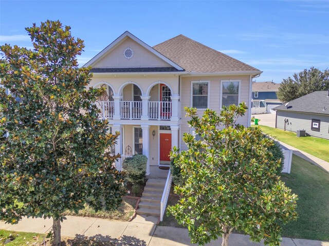 view of front of house featuring a balcony and a front yard