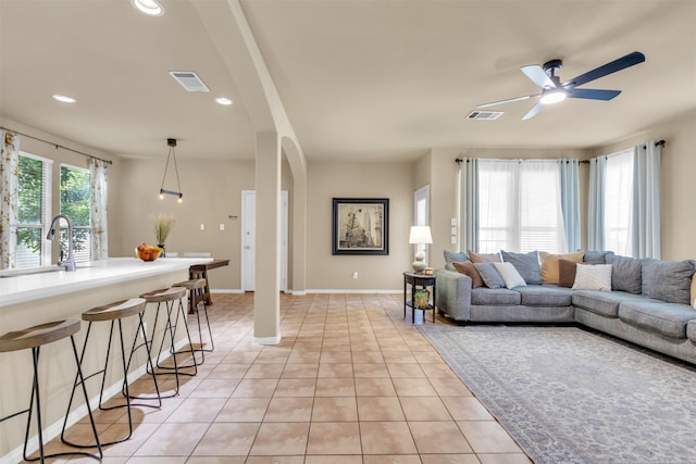 tiled living room with ceiling fan