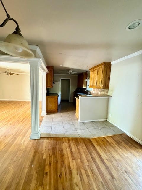 kitchen with light hardwood / wood-style flooring and ornate columns