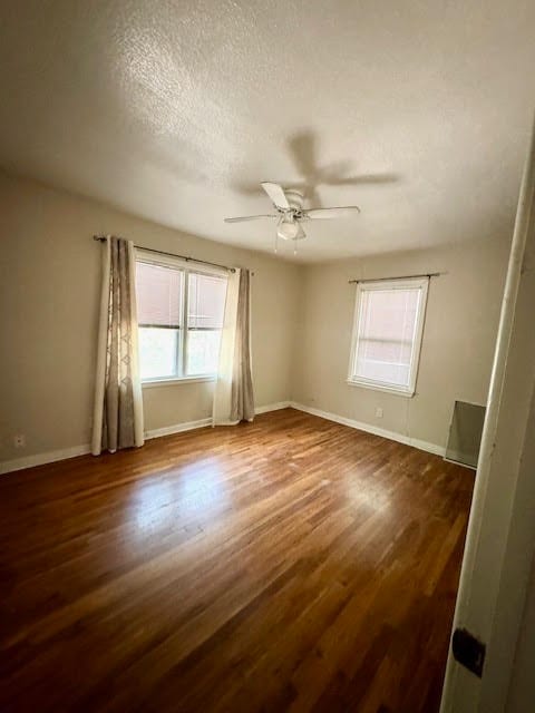 unfurnished room featuring wood-type flooring, a textured ceiling, and ceiling fan