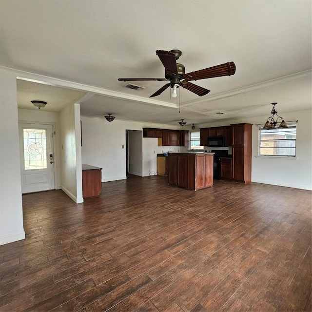 unfurnished living room with dark hardwood / wood-style floors, ornamental molding, ceiling fan with notable chandelier, and a wealth of natural light