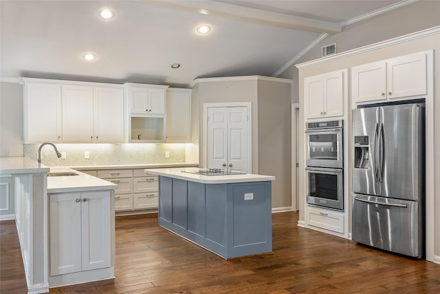 kitchen featuring stainless steel appliances, white cabinets, vaulted ceiling with beams, and sink