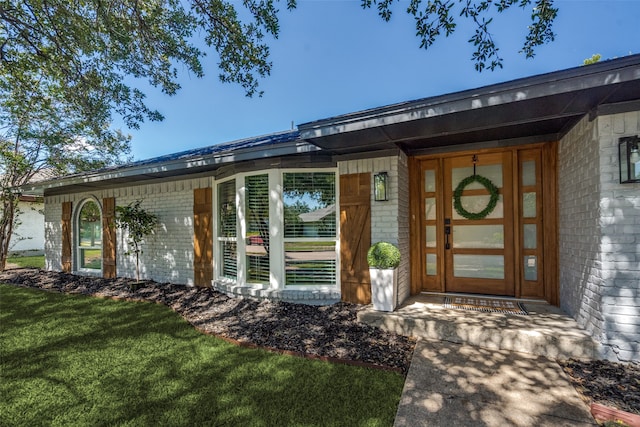 property entrance featuring a lawn