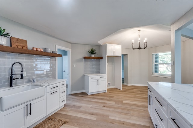 kitchen with backsplash, sink, and white cabinetry