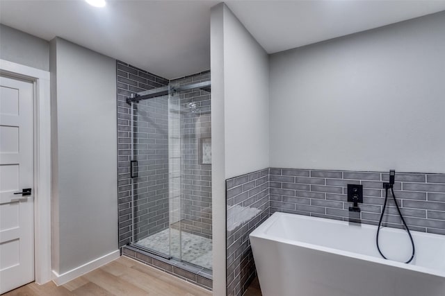 2625 Mollimar Dr, Plano, TX 75075 - full bath with baseboards, a freestanding tub, a stall shower, and wood finished floors