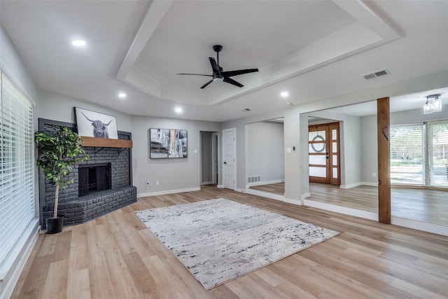 2625 Mollimar Dr, Plano, TX 75075 - living area featuring visible vents, ceiling fan, a tray ceiling, and a brick fireplace