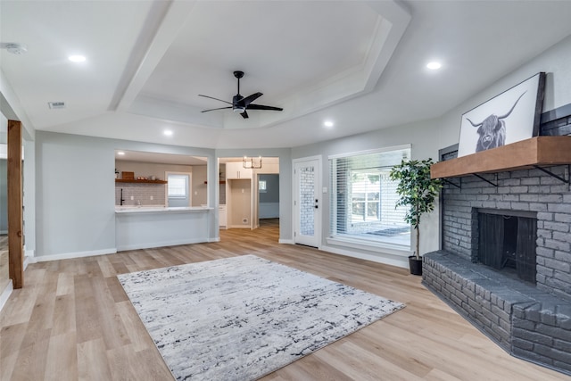 living room with light hardwood / wood-style floors, a fireplace, and ceiling fan