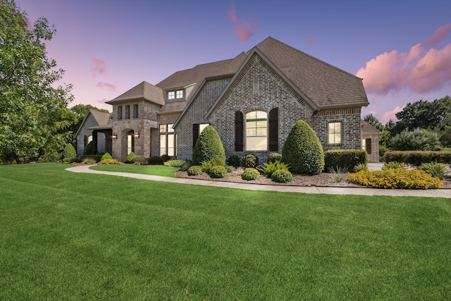 french country style house featuring a lawn