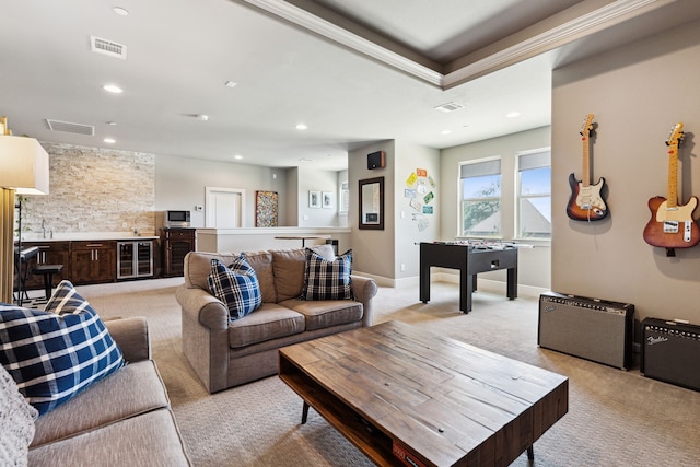 carpeted living room featuring wine cooler and sink