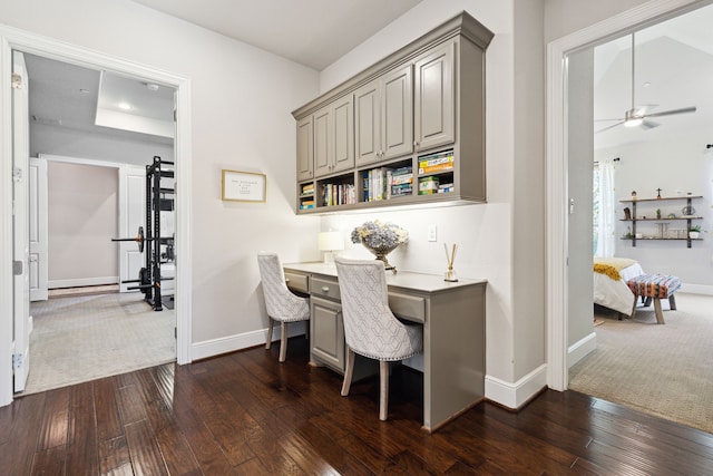 office space with built in desk, ceiling fan, and dark hardwood / wood-style floors