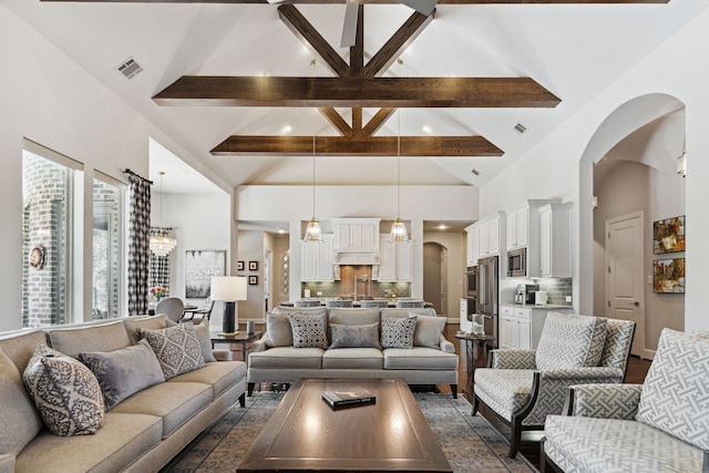 living room featuring beamed ceiling and high vaulted ceiling