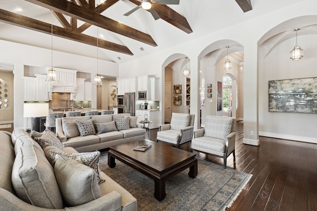 living room featuring ceiling fan, dark hardwood / wood-style floors, beam ceiling, and high vaulted ceiling