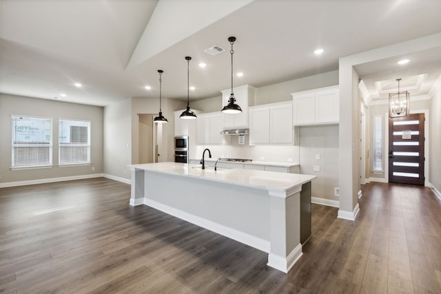 kitchen with a large island, dark hardwood / wood-style flooring, white cabinets, and hanging light fixtures