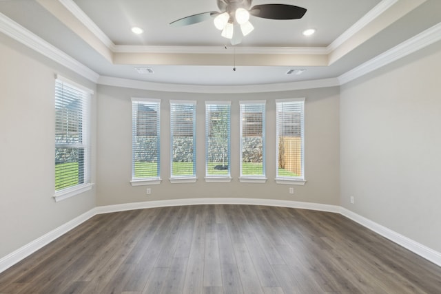 spare room featuring plenty of natural light, dark wood-type flooring, and ornamental molding