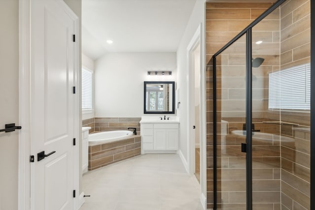 bathroom with tile patterned floors, vanity, separate shower and tub, and lofted ceiling