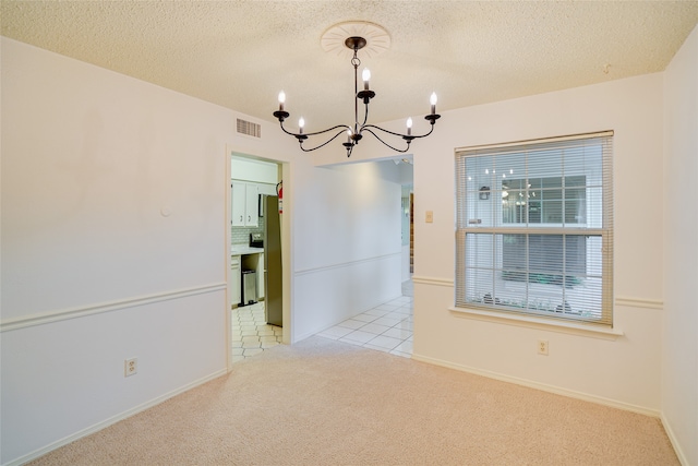 unfurnished dining area with light carpet, visible vents, an inviting chandelier, a textured ceiling, and light tile patterned flooring