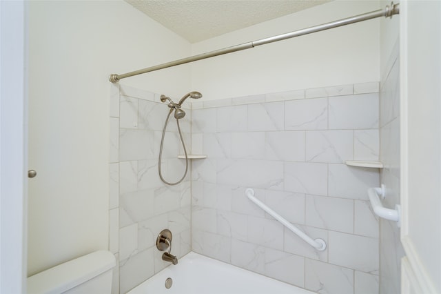 bathroom with a textured ceiling, bathing tub / shower combination, and toilet