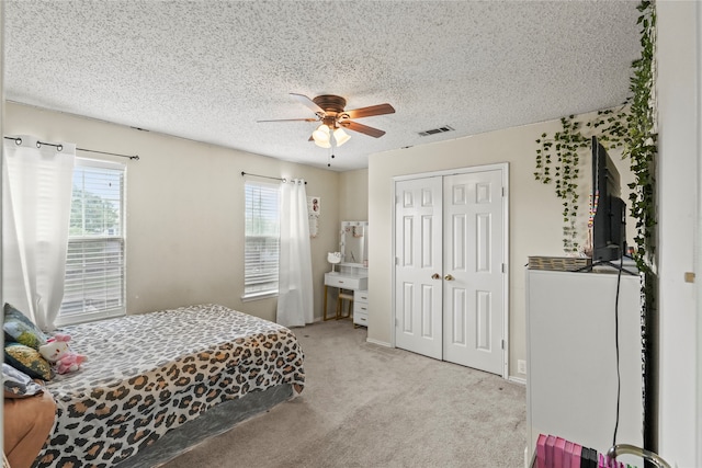 bedroom with multiple windows, light carpet, ceiling fan, and a closet