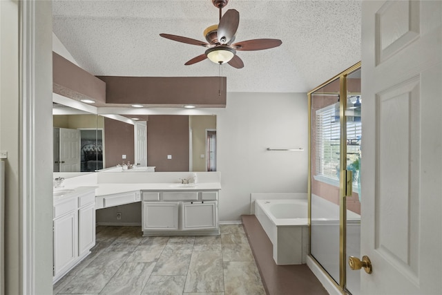 bathroom featuring ceiling fan, a textured ceiling, vanity, and a bathing tub