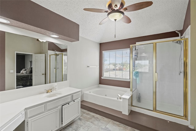 bathroom with a textured ceiling, vanity, and separate shower and tub