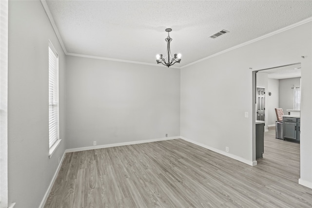 spare room with ornamental molding, light hardwood / wood-style floors, and a textured ceiling