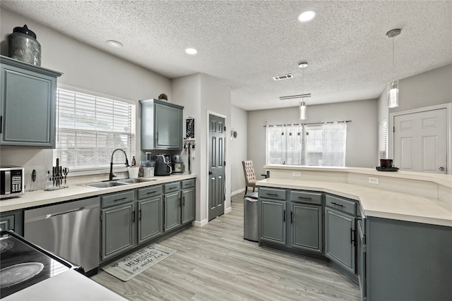 kitchen with stainless steel appliances, decorative light fixtures, light hardwood / wood-style floors, and a wealth of natural light