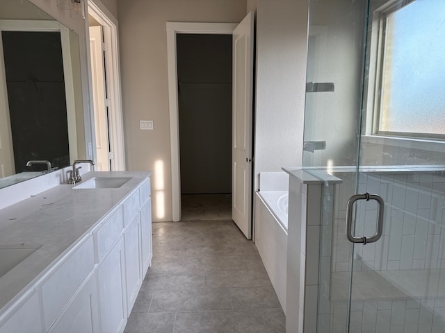 bathroom featuring shower with separate bathtub, vanity, and tile patterned floors