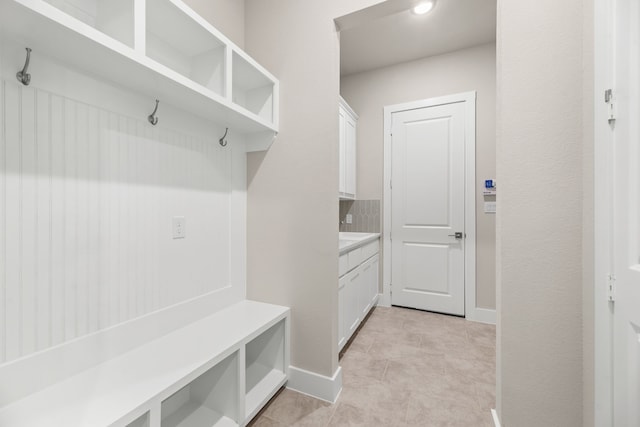 mudroom featuring light tile patterned floors and baseboards