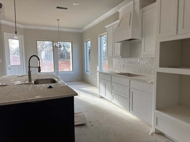 kitchen featuring tasteful backsplash, a center island with sink, white cabinets, and custom range hood