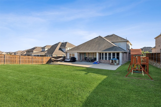 rear view of house featuring a patio, a playground, and a lawn