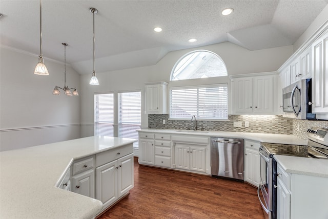 kitchen with dark wood-type flooring, sink, white cabinets, vaulted ceiling, and appliances with stainless steel finishes