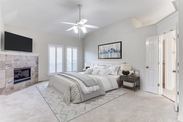 carpeted bedroom with ceiling fan and a tile fireplace