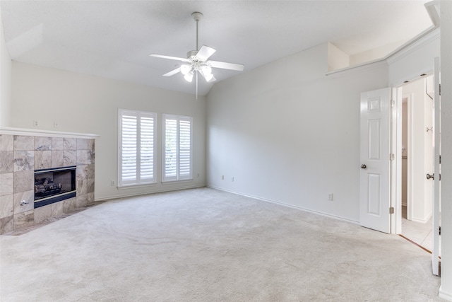 unfurnished living room featuring a tiled fireplace, light colored carpet, and ceiling fan